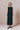 Sleeveless black cotton dress with textured finish and button details